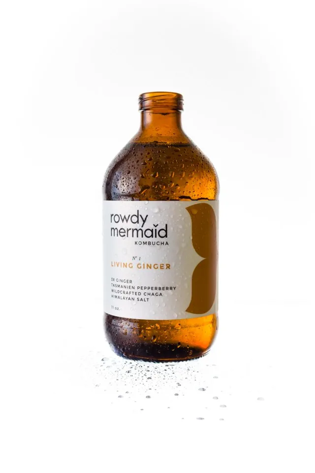 An amber glass bottle with a white label against a white background.