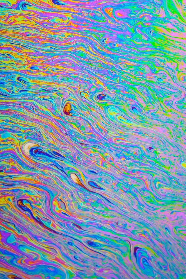 Dense ripples of pink, green, blue, and yellow create an iridescent abstract pattern.