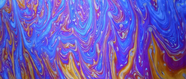 Repeating violet, blue, orange, and pink swirls fill an abstract panorama.